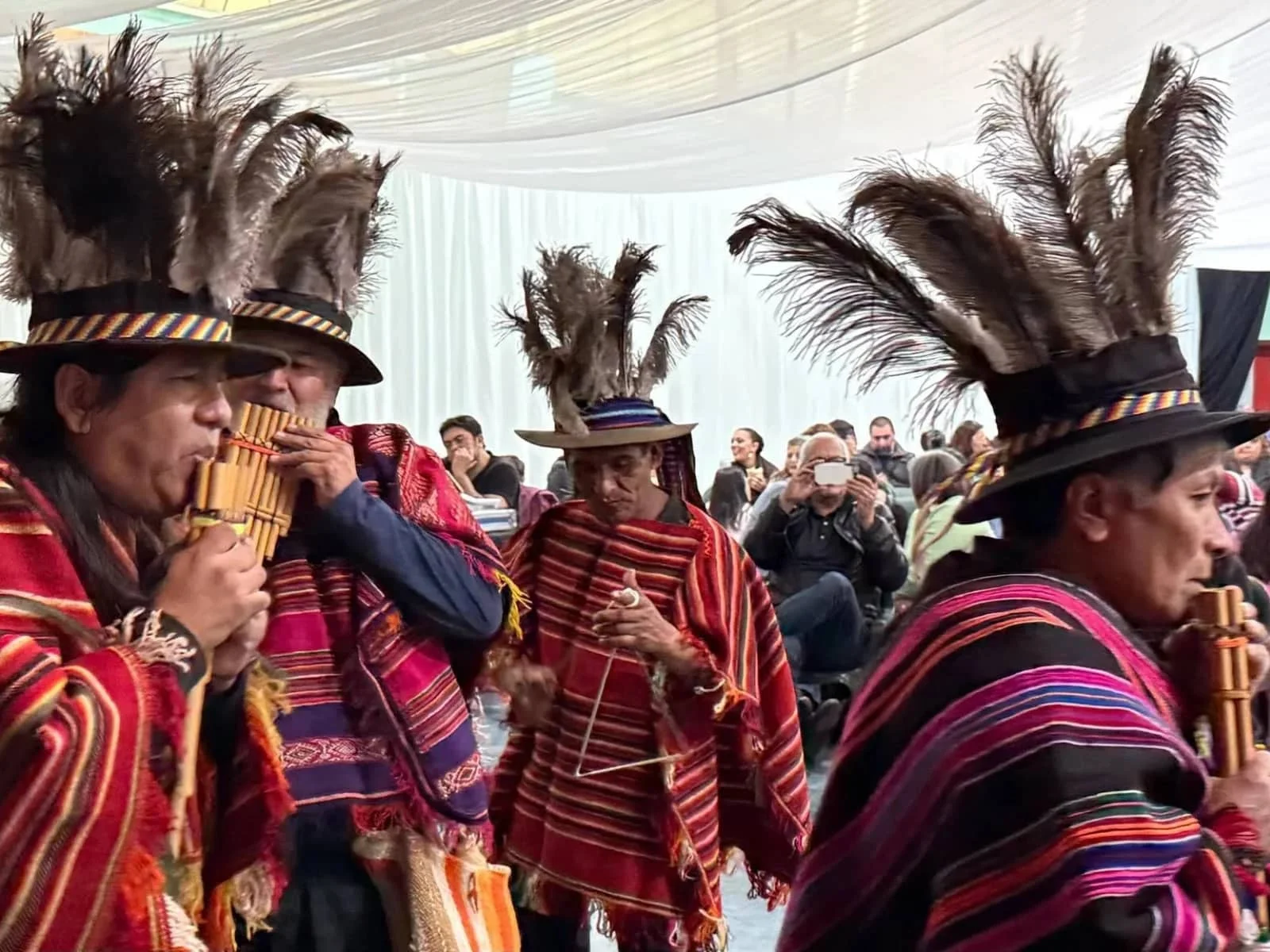 Inicio Grupo de músicos andinos con ponchos tradicionales y sombreros con plumas tocando zampoñas